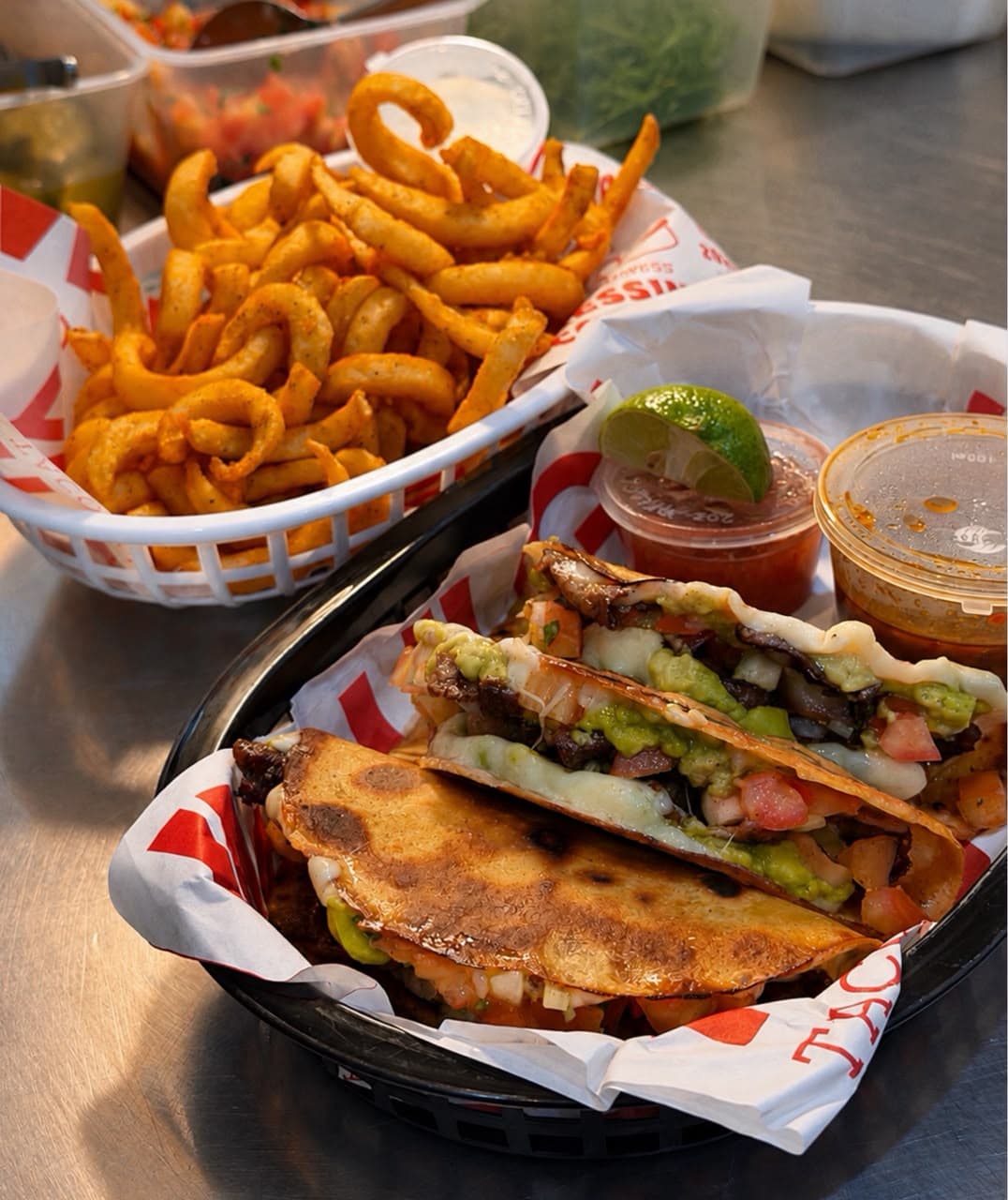 Cajun lamb tacos with melted cheese, guacamole and pico salsa, with curly fries