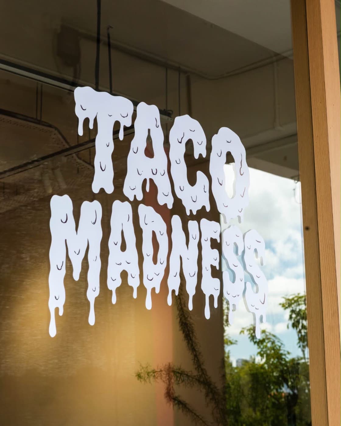 Taco Madness dripping logo decal on the storefront window